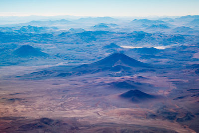 Aerial view of mountains against blue sky