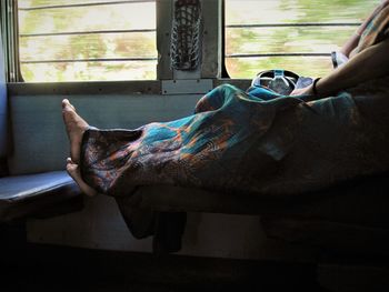 Barefoot woman traveling by train
