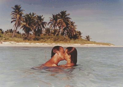 Happy young woman at beach against sky