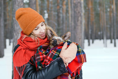 Midsection of person with dog during winter