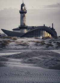 View of lighthouse by sea against sky