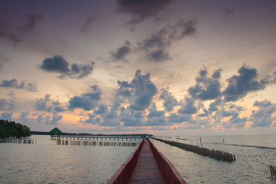 Pier over sea against sky during sunset