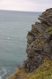 Rock formation on sea shore against sky