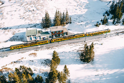 Train on railroad track by snowcapped mountain