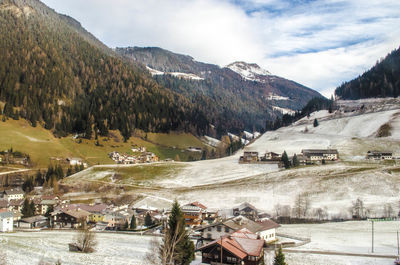 Scenic view of village and mountains against sky