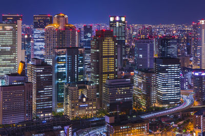 Illuminated buildings in city against sky at night