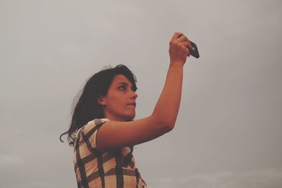 Low angle view of woman standing against sky