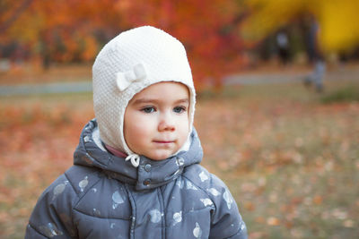 Close up portrait of cute little baby girl on autumn orange background.