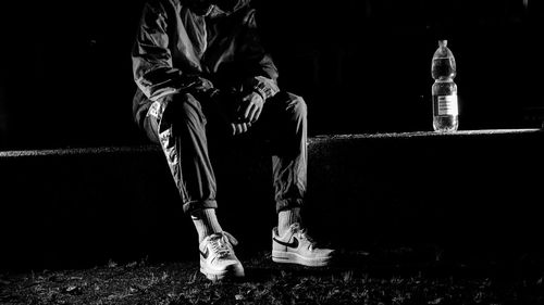 Low section of man sitting at night