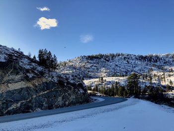 Snow covered landscape against blue sky