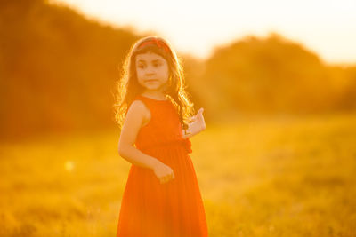 Portrait of girl standing on land during sunset