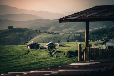 House ad agricultural field against mountains