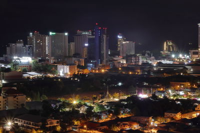 Illuminated buildings in city against sky at night