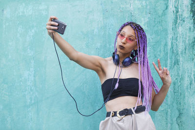 Young woman photographing with mobile phone