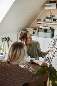 Women sitting at desk and discussing art project