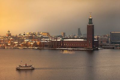 Ship in sea against buildings in city