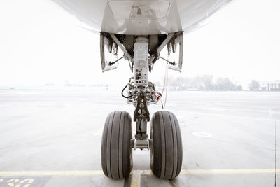 Close-up of airplane on airport runway against clear sky