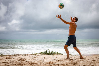 Rear view full length of young man running at beach