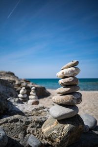 Stack of stones on beach against sky