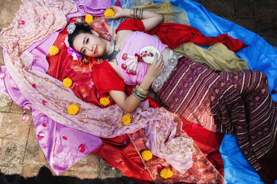 High angle portrait of woman lying on textile