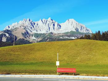 Built structure on field against snowcapped mountains against sky