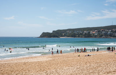 People on beach against sky