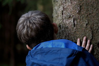 Rear view of boy against tree