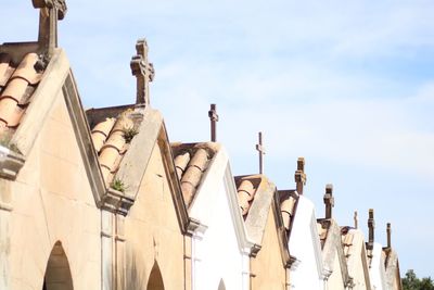 Low angle view of statues on building against sky