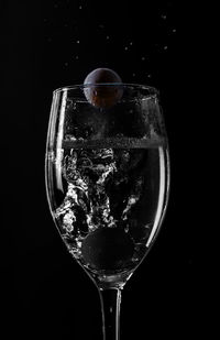 Close-up of wine glass against black background