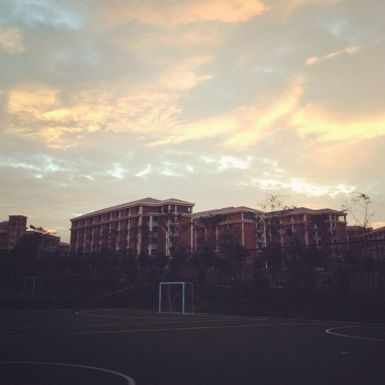 architecture, building exterior, built structure, sky, cloud - sky, sunset, city, cloudy, building, cloud, residential building, residential structure, outdoors, street, low angle view, road, no people, orange color, dusk, overcast