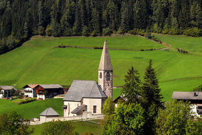 High angle view of cottage amidst trees and buildings