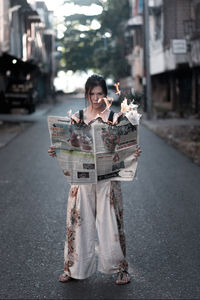 Woman standing on road in city