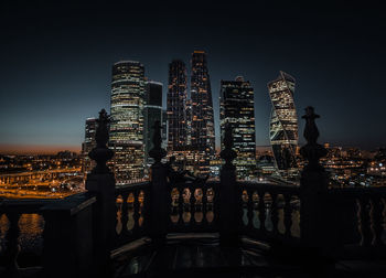 Illuminated buildings against sky at night