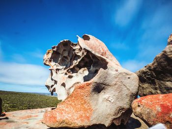 Close-up of rocks on land against blue sky