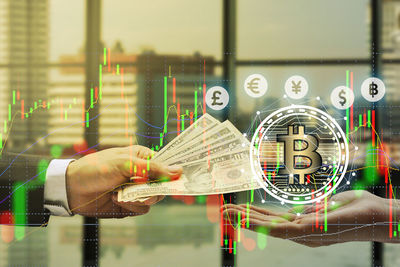 Digital composite image of hand giving us dollars and bitcoin