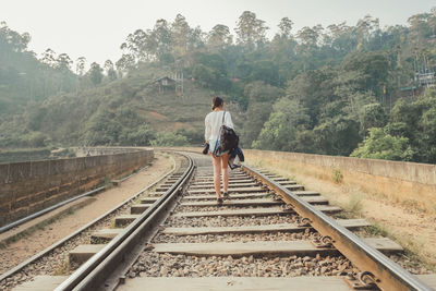 Rear view of man standing on railroad track