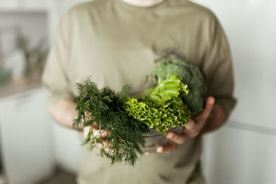 Midsection of woman holding plant