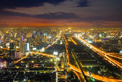 High angle view of illuminated cityscape against sky at night