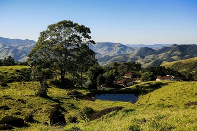 Scenic view of landscape and mountains against clear sky