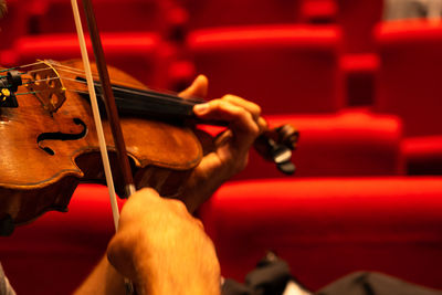 Midsection of man playing guitar at music concert