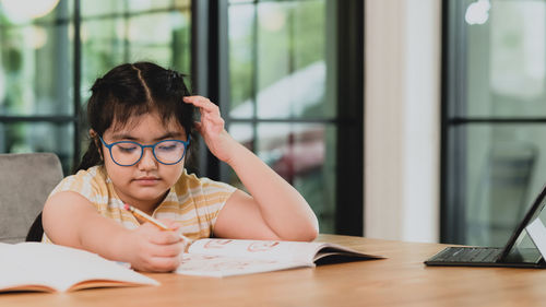 Portrait of boy sitting on table