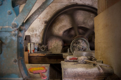 Image of the interiors of an old water mill with a rusty  wheel 