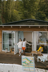 Multiracial couple standing together on porch at doorway