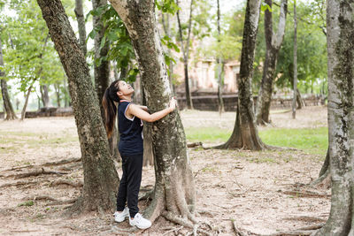 Young woman hugging a big tree, love nature concept.