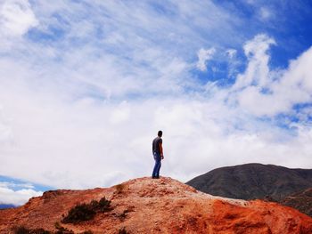 Man standing on cliff against sky