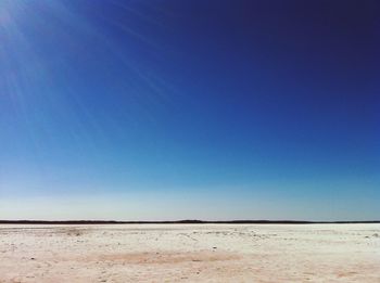 Scenic view of desert against clear blue sky