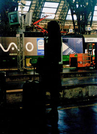 Man photographing city against sky at night