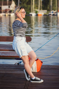 Attractive woman posing on the marina at a sunny summer day