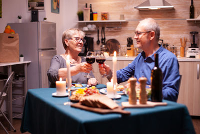 Portrait of smiling friends having food at home