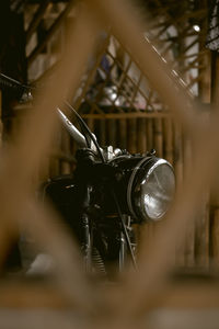 Motorcycle headlight seen through fence